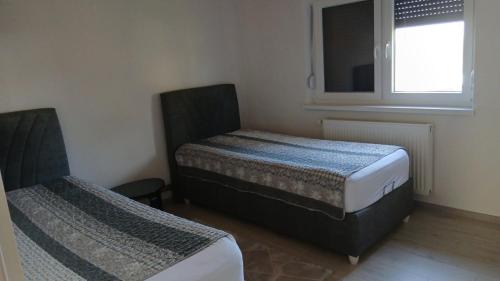 a bedroom with two beds and a window at Kuća za odmor Tarik in Cazin