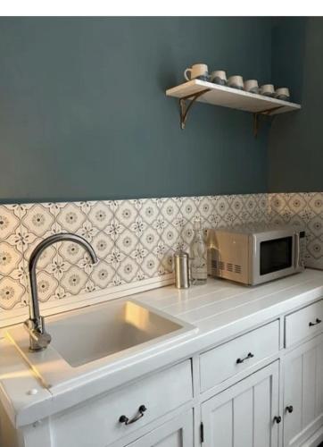 a kitchen counter with a sink and a microwave at Fairlawn House in Amesbury