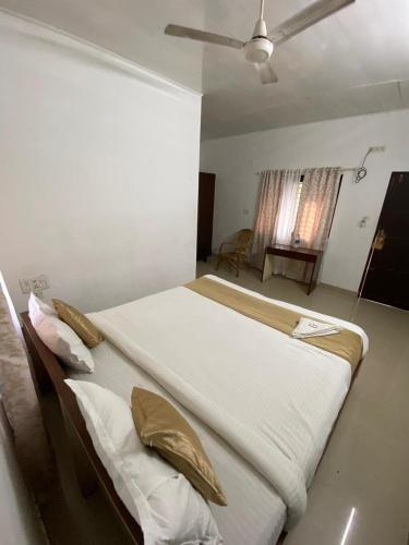 a large bed in a bedroom with a ceiling fan at villas alleppey in Alleppey