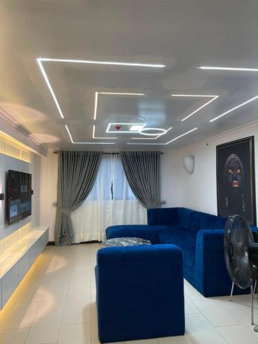 a living room with a blue couch and blue chairs at Teddy apartment in Lagos