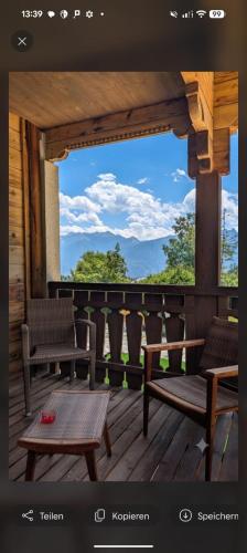 a balcony with two benches and a view of the mountains at Guesthouse Hotel Between in Chamoson