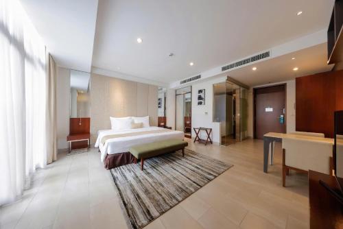 a large bedroom with a bed and a living room at SILA Urban Living in Ho Chi Minh City