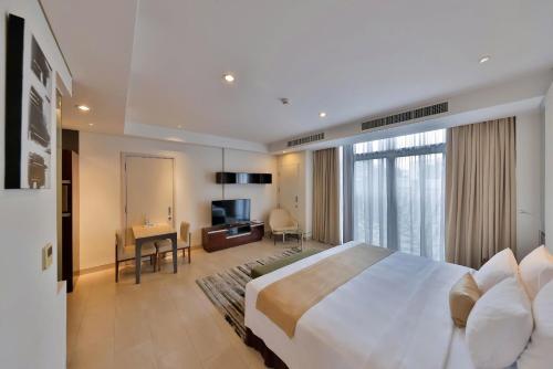a hotel room with a large bed and a television at SILA Urban Living in Ho Chi Minh City