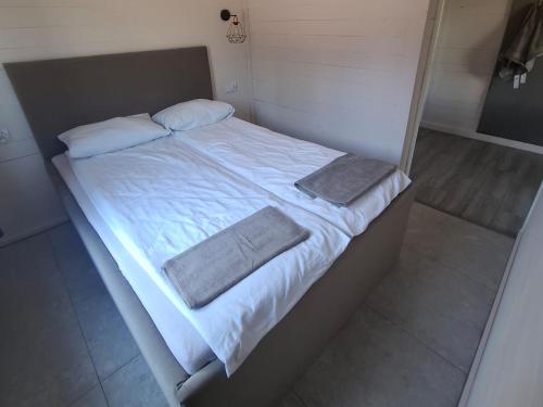 a large bed with white sheets and pillows on it at domek 3 osoobowy in Augustów
