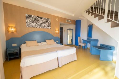 a bedroom with a large bed and a staircase at Hotel Drago Park by Pierre & Vacances in Costa Calma