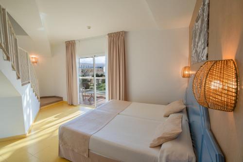 a bedroom with a bed and a large window at Hotel Drago Park by Pierre & Vacances in Costa Calma