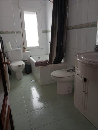 a white bathroom with a toilet and a sink at Casa Oskar in Avilés