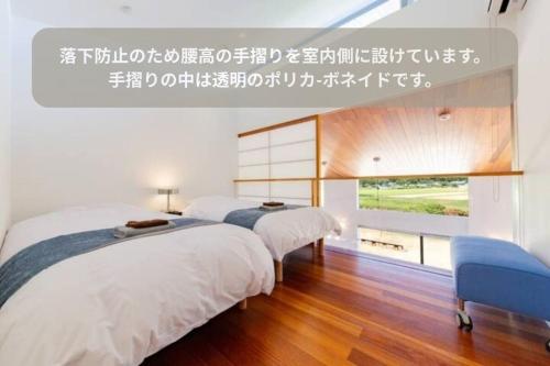 two beds in a white room with a window at The SATOYAMA HILLS FK1 in Futtsu