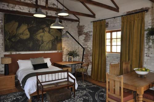 a bedroom with a bed with a painting on the wall at SOUSIE'S RUSTIC STAY in Polokwane