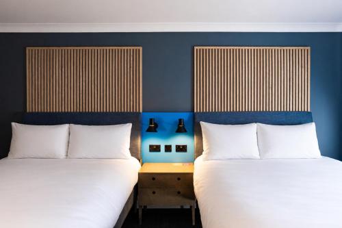 two beds sitting next to each other in a room at Village Hotel Leeds North in Leeds