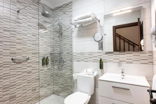 a bathroom with a shower and a toilet and a sink at Ona Las Rosas in Puerto de Santiago