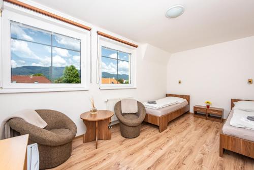 a room with a bed and two chairs at Penzion Maja in Martin