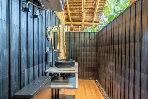 a bathroom with a sink and a bowl on a table at Mare Eco Bungalows - Kids & Family friendly in Kuta Lombok