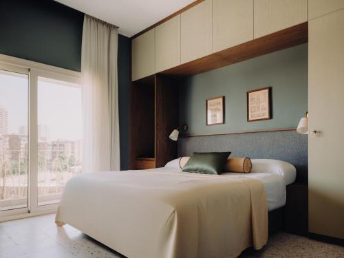 a bedroom with two beds and a large window at Longchamps l Zamalek l Boutique Hotel with Breakfast in Cairo