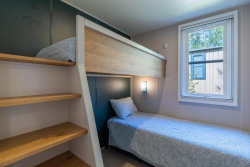 a small bedroom with a bunk bed and a window at Camping le Clou in Coux-et-Bigaroque