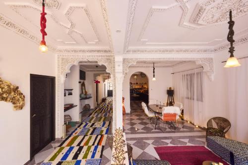 a living room with a white ceiling and a dining room at Dar D'art Luz Galerie Boutique Guest house in Al Ghar