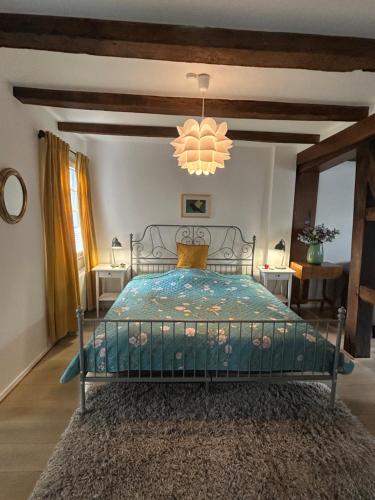 a bedroom with a bed and a chandelier at Fachwerkjuwel im Bergischen in Remscheid