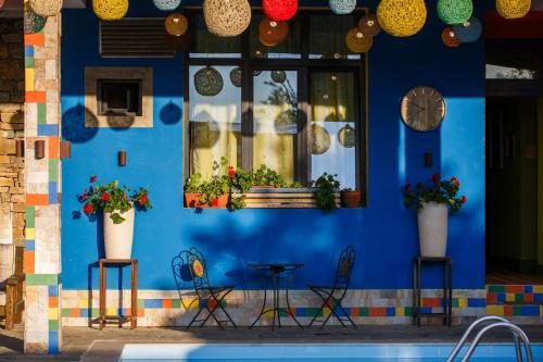 a blue wall with two chairs and a table with plants at Boutique Hotel Casa Art in Oreshak