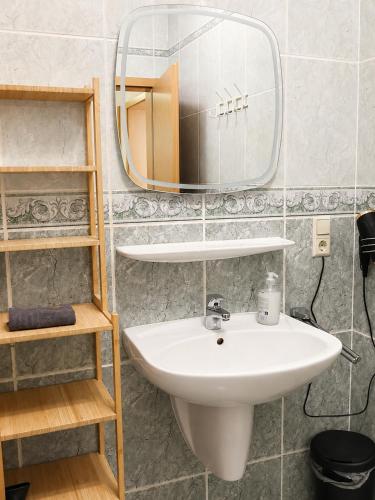 a bathroom with a sink and a mirror at Comfort & Central Rooms in Luxembourg