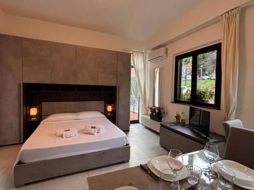 a bedroom with a bed and a tv and a table at Due laghi – Studio Apartment with Pool in Porlezza