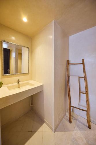 a bathroom with a sink and a mirror and a chair at Dar D'art Luz Galerie Boutique Guest house in Al Ghar
