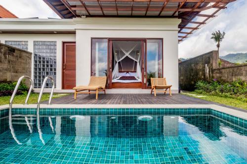 a villa with a swimming pool and a bedroom at Pelangi Villas Sidemen by AGATA in Sidemen