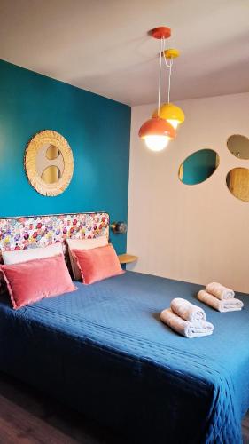 a bedroom with a blue bed with two towels on it at AMARRÉ Gîte Bambou T2 Chambre indépendante in Sarzeau