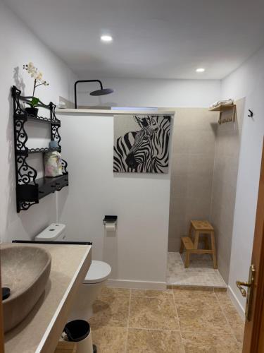 a bathroom with a zebra painting on the wall at Can Content - Platja de Muro in Playa de Muro