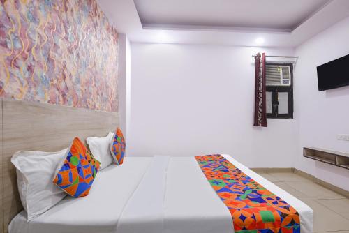 a bedroom with a bed and a painting on the wall at FabHotel Snereya in New Delhi