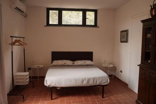a bedroom with a bed and two tables at La stamberga nel bosco in Asciano Pisano