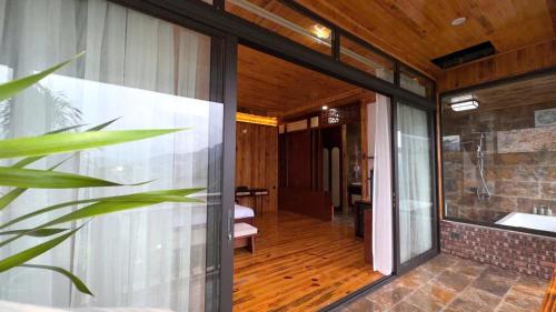 a glass door leading into a room with a hallway at Sapa Rose Garden Resort in Sapa