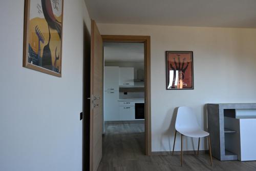 a room with a hallway with a table and a white chair at Chalet du Sky PILA in Cerise
