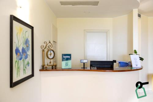 an office with a desk and a clock on a wall at Hotiday Tropea Parghelia in Tropea
