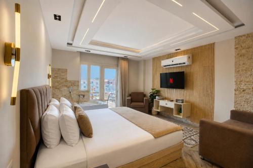 a hotel room with a bed and a television at Premium Pyramids BoutiQue With Rooftop Access in Cairo