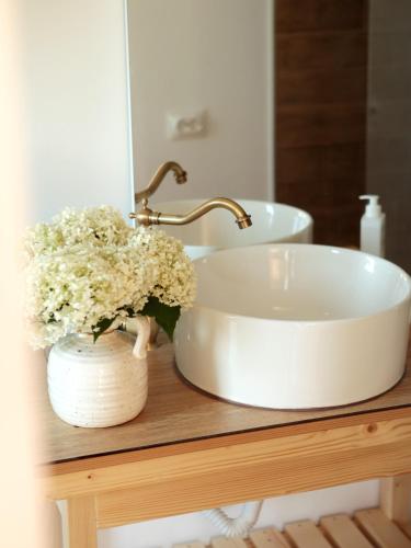 a bathroom sink with flowers on a wooden table at Cabana din vale in Cioclovina