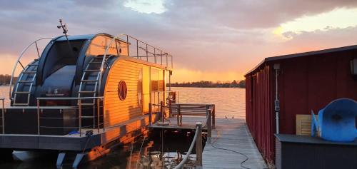 a boat is docked on a dock in the water at Seeblick Hausboot Sambesi in Königs Wusterhausen