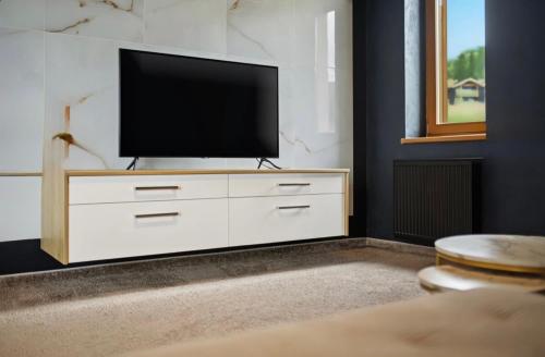 a living room with a television on a white dresser at Donovaly Residence Apartment 111 in Donovaly
