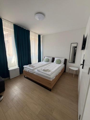 a bedroom with a bed in a room with blue curtains at Capital Stay Old Town in Sarajevo