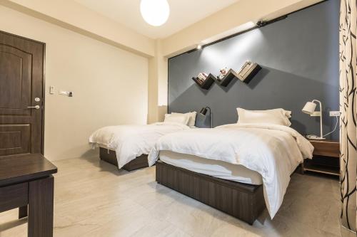 two beds in a bedroom with a large wall at Starting Point B&B in Hualien City