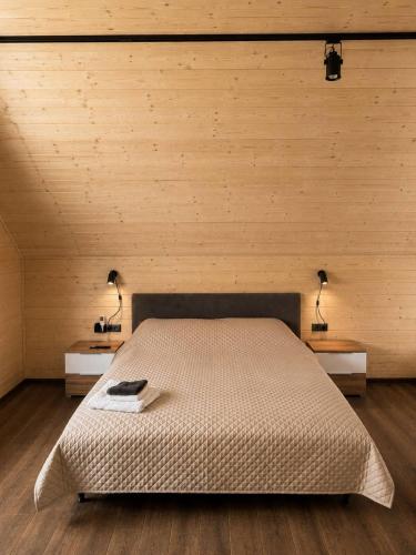 a bedroom with a bed and two lamps on two tables at Joy WoodRest in Voropayev