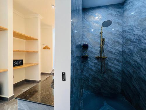 a bathroom with a shower with a blue wall at Apsara Resort Koh Rong in Koh Rong Island