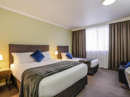 a hotel room with two beds and a window at Mercure Albury in Albury