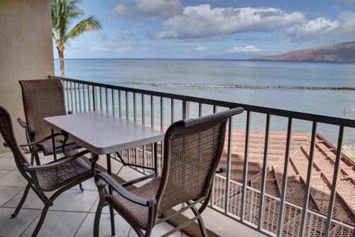 a table and chairs on a balcony overlooking the ocean at Menehune Shores 309 in Kihei