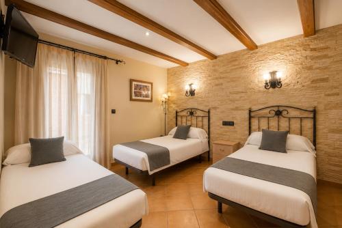a hotel room with two beds and a television at Alda Casco Antiguo in León
