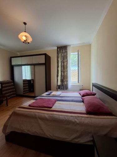 a large bed with red pillows in a bedroom at Villa Borjomi in Akhaldaba