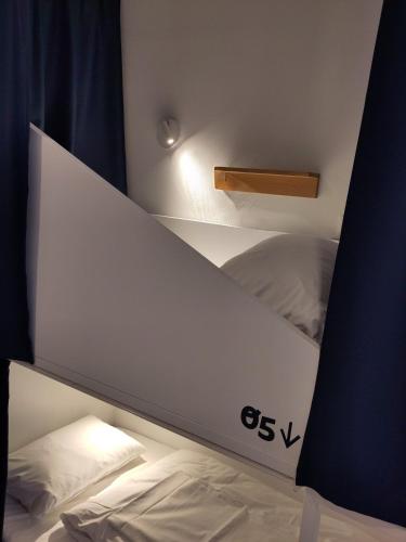 a white laptop computer sitting on top of a bed at SLO Hostel Lyon Saxe in Lyon