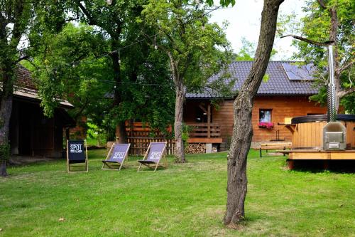 two lawn chairs sitting in the grass in front of a cabin at Pod Dzwonkiem in Jasienica