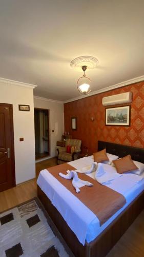 a bedroom with a large bed with a white animal on it at Boomerang Guest House in Selçuk