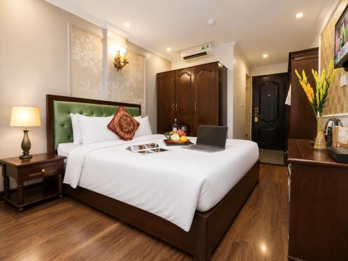 a bedroom with a bed with a laptop on it at Golden Sail Hotel & Travel in Hanoi