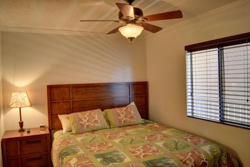 - une chambre avec un lit et un ventilateur de plafond dans l'établissement Pacific Shores B306, à Kihei